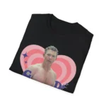 A folded black t-shirt showing a close-up of the "G D MORNING" shirtless man graphic.